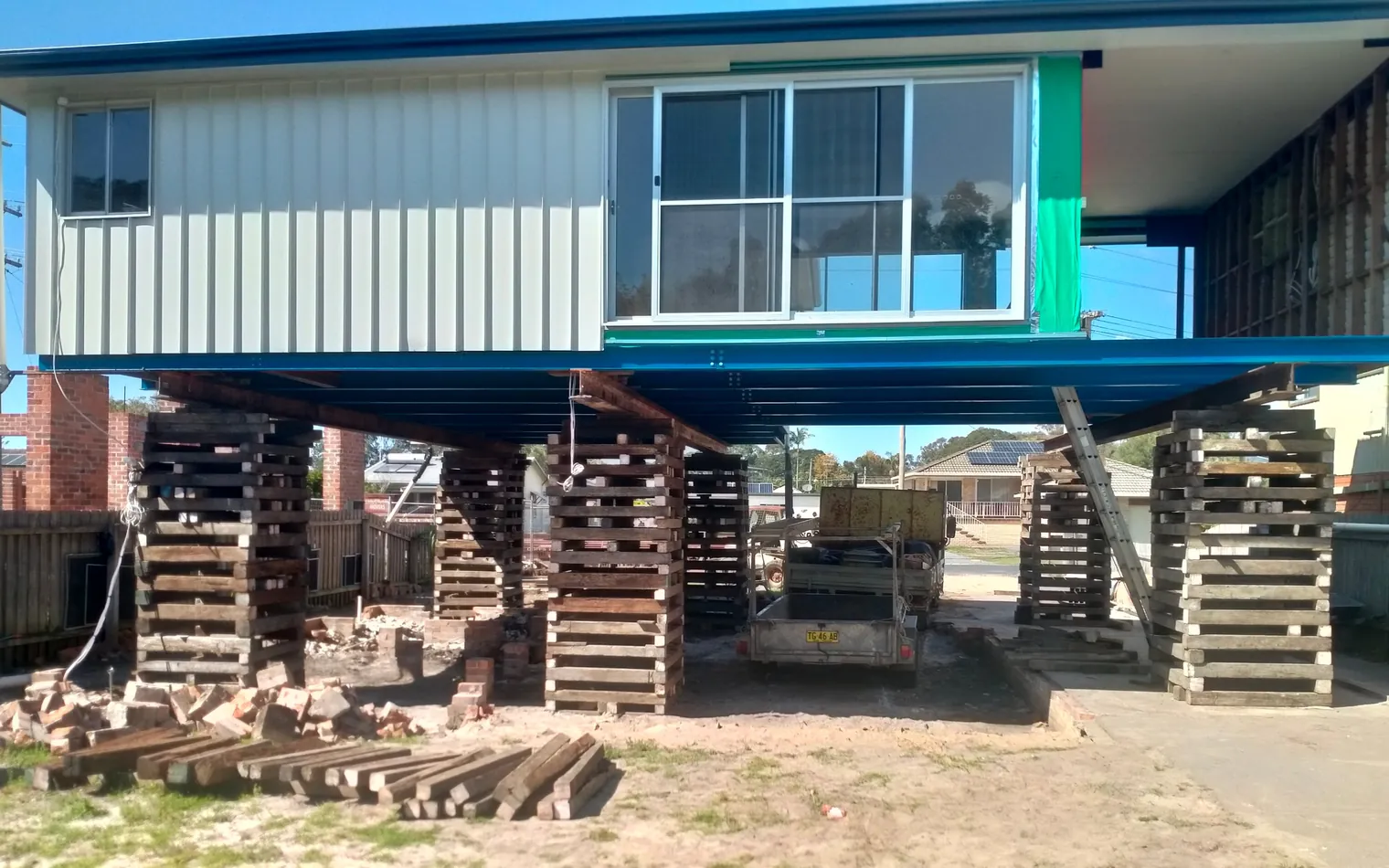 Home lifted on timber cribbing with new steel beams installed underneath